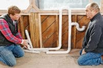Plumbing_0519-Brookline-P1010292–Mike-Last.0 Kevin O'Connor and Richard Trethewey look at PVC pipes that are part of a plumbing project.
